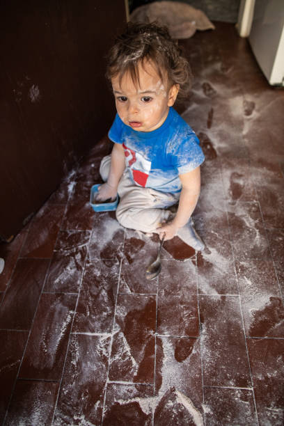 istock Toddler boy making a mess with flour at kitchen 1248703168