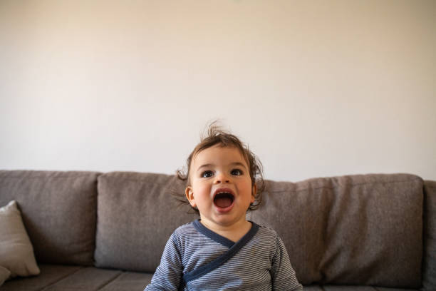 istock Cheerful little boy on sofa at home 1248703212