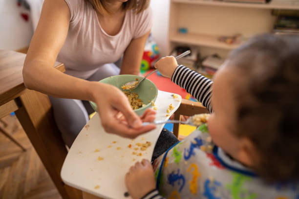 istock Single mother feeding her toddler boy at home 1248703640