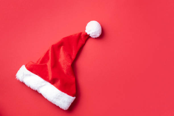 istock Red Santa Claus hat on red background. Top view. Copy space. Advent time. New year composition. Decoration for winter holidays celebration. Christmas greeting card 1248703696