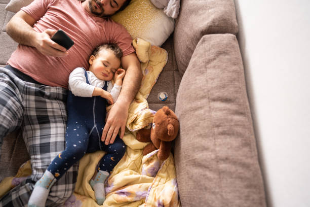 istock Father surfing the net while his son napping during weekend day 1248703730