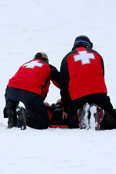 Ski Patrol At Work Ski Patrol working on a young boy who hurt his neck while skiing. ski patrol photos stock pictures, royalty-free photos & images