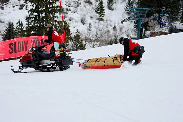 socorrista de esquí transporte ingured esquiador en montañas - ski insurance fotografías e imágenes de stock