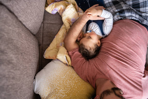 istock Baby boy having a nap with his dad on sofa 1248707121