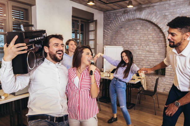 istock Business people making team training exercise during team building seminar singing karaoke. 1248707936