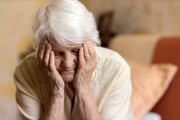 istock Senior woman holding head in hands in despair 1248708508