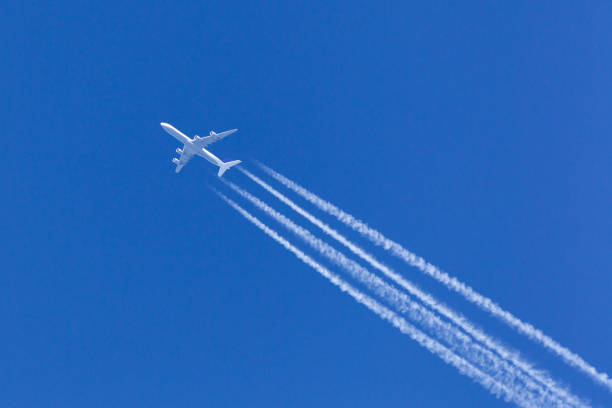 istock Airliner with a large contrail flying across a clear blue sky. 1248710076