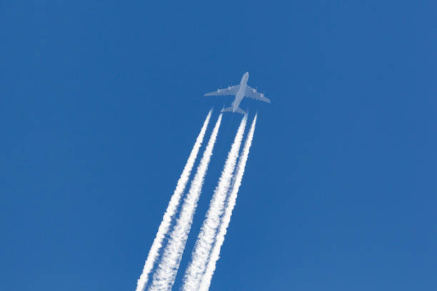 istock Airliner with a large contrail flying across a clear blue sky. 1248710230
