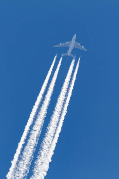 istock Airliner with a large contrail flying across a clear blue sky. 1248710335