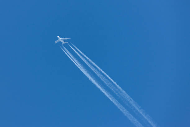 istock Airliner with a large contrail flying across a clear blue sky. 1248711103