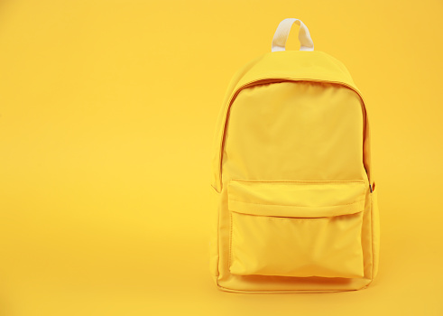 Yellow backpack empty space background,travel concept.Rucksack education symbol.Back to school september 1.