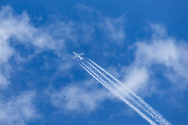 istock Airliner with a large contrail flying above the clouds. 1248711786