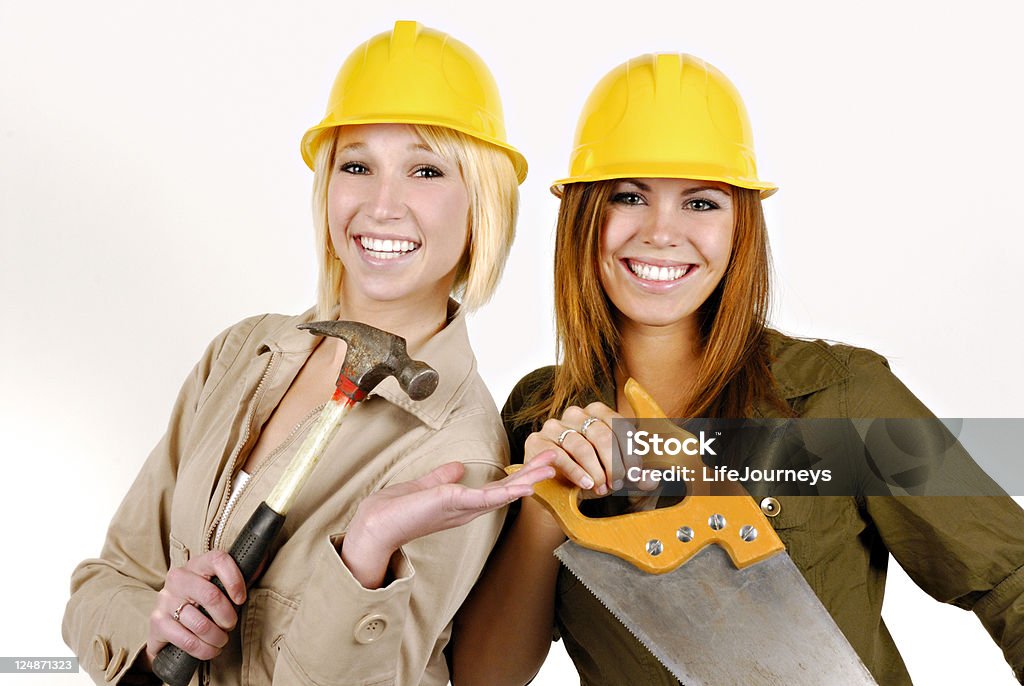 Construction:  Tool Time Two Women. Yellow Hard Hats, Hammer, Saw. Expressive Smiles and Wide Eyed Look! Adult Stock Photo