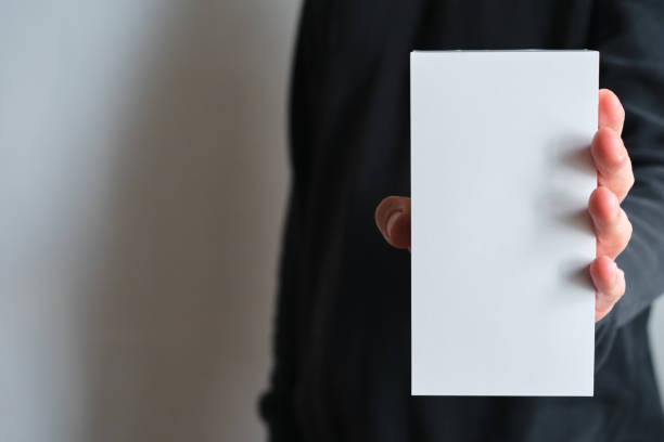 istock Man holding in hand small paper box. Blank packing, empty space. Male with a new package. Postal service, delivery. White paper. Gift box, present. Box close up. People communication. Carton case 1248713281
