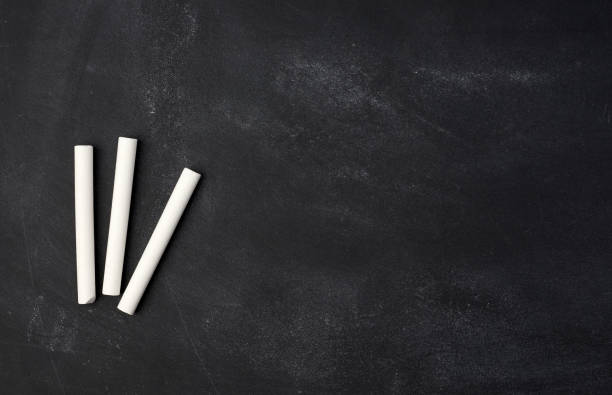 istock empty wet black chalk board and white chalk sticks 1248713599