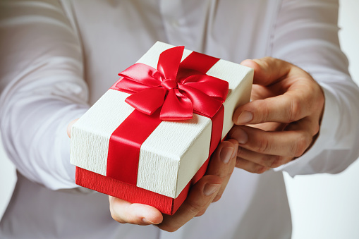 A man gives a gift, close-up. Holidays concept