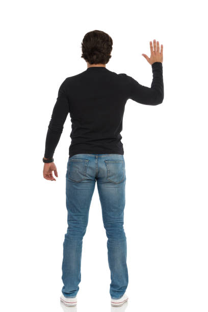 istock Rear View Of Standing Man With Arm Raised 1248717020