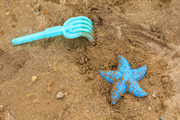 jouets en plastique oubliés pour enfants sur le sable sur la plage. concept de vacances, voyage, été, vacances, crise des affaires touristiques, verrouillage, annulation due au coronavirus, covide-19. - beach cancelled close up color image photos et images de collection