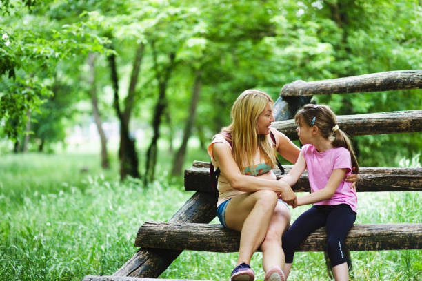 istock Mother and daughter talking together in the woods 1248721821