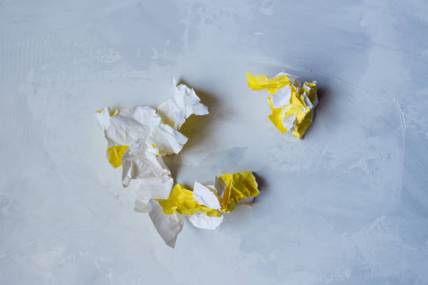 istock Torn, crumpled sheet of yellow paper on a gray background 1248721908