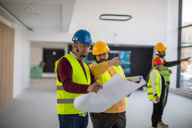 istock Construction engineers looking at blueprint and discussing about work inside of building 1248722801