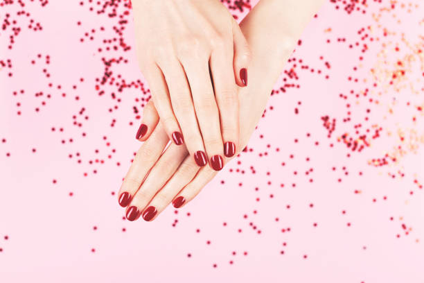 istock Two woman hands and falling confetti on pink background. 1248723074