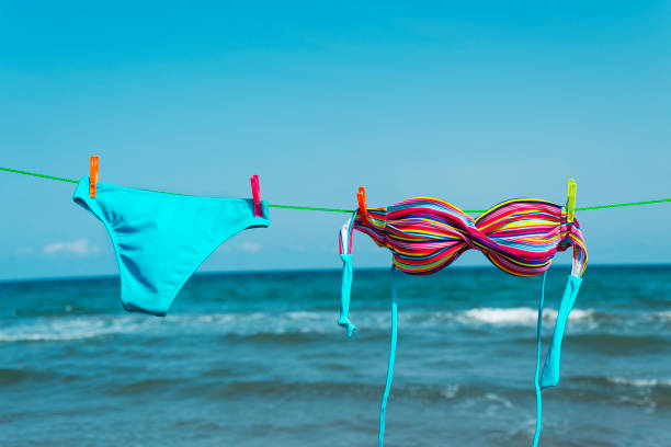 bikini suspendu sur une ligne de vêtements sur la plage - bra lingerie clothesline underwear photos et images de collection