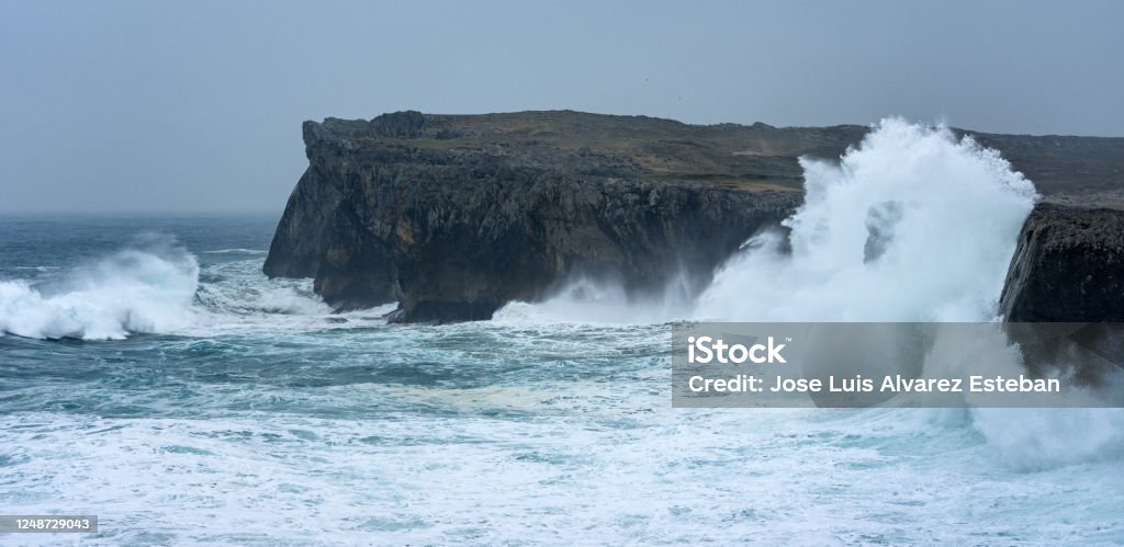Landscape of the karst limestone sea cliffs in Asturias in the Llanes coast, North of Spain, with the waves cruhsing against the cliffs. Cliff Stock Photo