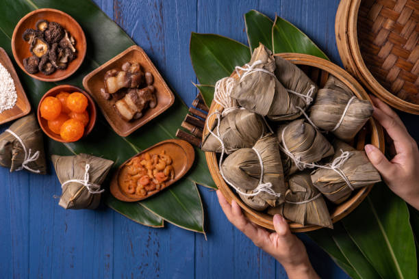 zongzi - Dragon Boat Festival concept Rice dumpling, traditional Chinese food on blue wooden background for Duanwu Festival. zongzi - Dragon Boat Festival concept Rice dumpling, traditional Chinese food on blue wooden background for Duanwu Festival, top view, flat lay design concept. traditional malaysian food stock pictures, royalty-free photos & images