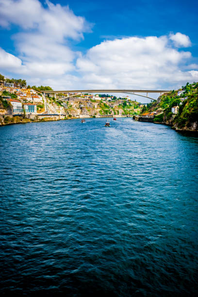 A boat full of tourists on the Douro river in Porto during a sunny day of summer.