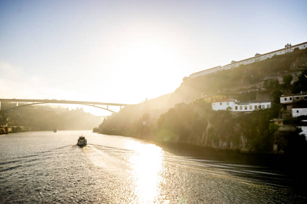 A boat full of tourists on the Douro river in Porto during a sunny day of summer.