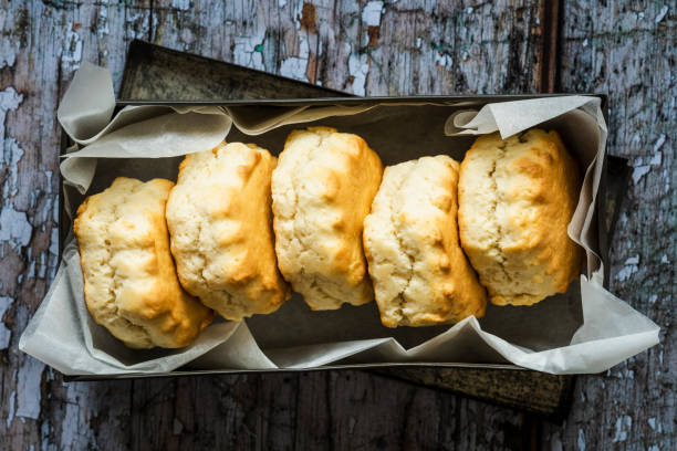 Five freshly baked scones in a greaseproof lined metal tin
