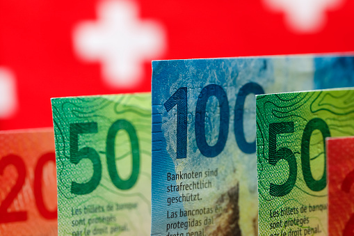 The symbols of the Swiss flag is seen behind the Swiss banknotes of various denominations. These new banknotes are the eighth series of banknotes which were introduced between 2016 and 2019.