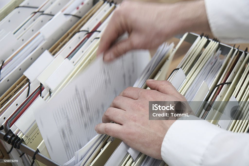 searching in a file cabinet hands searching in a file cabinet Document Stock Photo