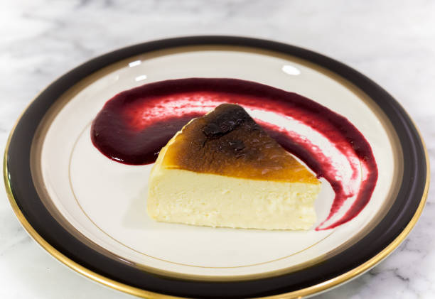 dessert basque brunt cheesecake with berries sauce on a plate. - brunt imagens e fotografias de stock