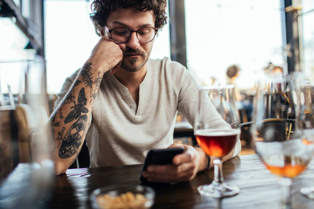 istock On his phone while his date is in the bathroom 1248734221
