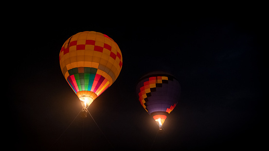 2 balloons of various colors floating at night