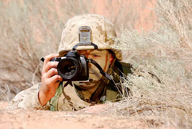 Lone Soldier In Desert Camouflage with Camera on recon mission.