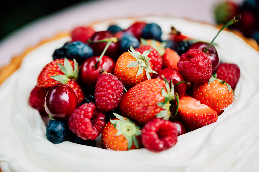 Close-up of a fresh homemade fruit cake on a table. Delicious cheesecake with berries.