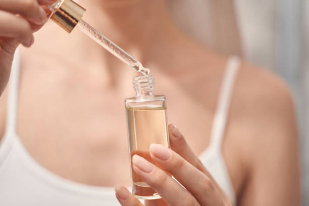 woman performing a beauty procedure at home - moisturizer cosmetics merchandise human hand imagens e fotografias de stock