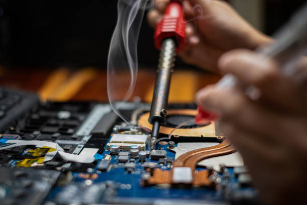 istock Close-up hand technician repairing broken laptop notebook computer with electric soldering Iron 1248737451