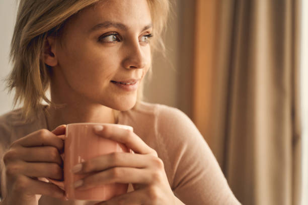 istock Dreamy young woman with a hot beverage 1248737610