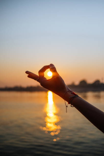 Yoga Woman Hands Yoga Mudra hand pose against a warm sunset background. mudra stock pictures, royalty-free photos & images