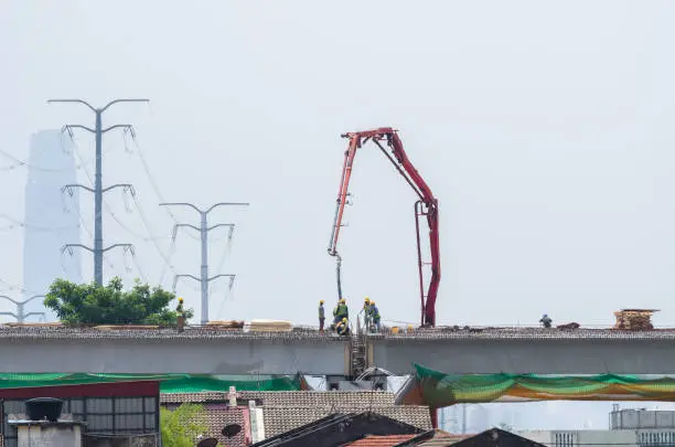 Photo of Scene view of the workers working on the construction of a highway bridge.