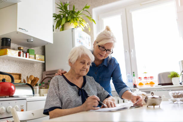 istock Mature woman helping elderly mother with paperwork 1248740157