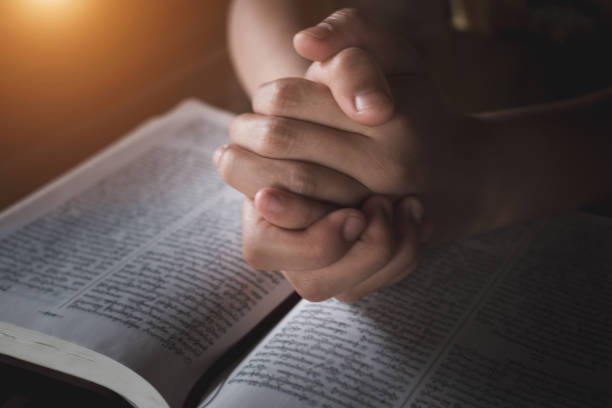 istock A young woman sat and studied the scriptures laid on a wooden table. The educational concept of the Christian Tripitaka that is open and praying to God Faith in the divine power of God. Bible study. 1248740237