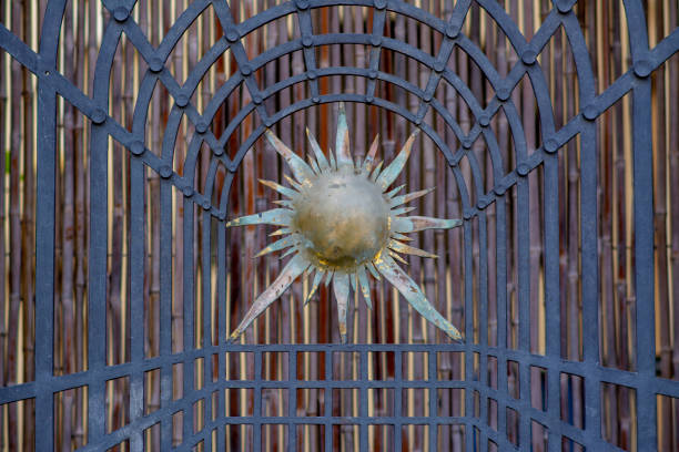 Openwork gates made of forged metal with golden symbols of the falling tower of Syuyumbike. A fragment of the gate in close-up. Russia, Republic of Tatarstan, Kazan, September 2023