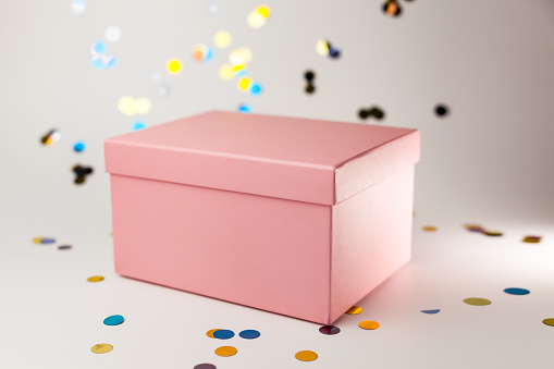 Pink gift box on white background with confetti. for commerce shopping on winter holidays birthday Party concept.