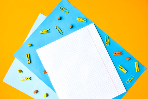 istock white squared paper from notebooks, wooden colored clothespin, paper clips, copy space for text, back to school concept, Stationery office supplies 1248743150