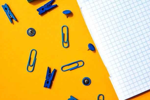 istock white squared paper from notebooks, wooden colored clothespin, paper clips, copy space for text, back to school concept, Stationery office supplies 1248743394